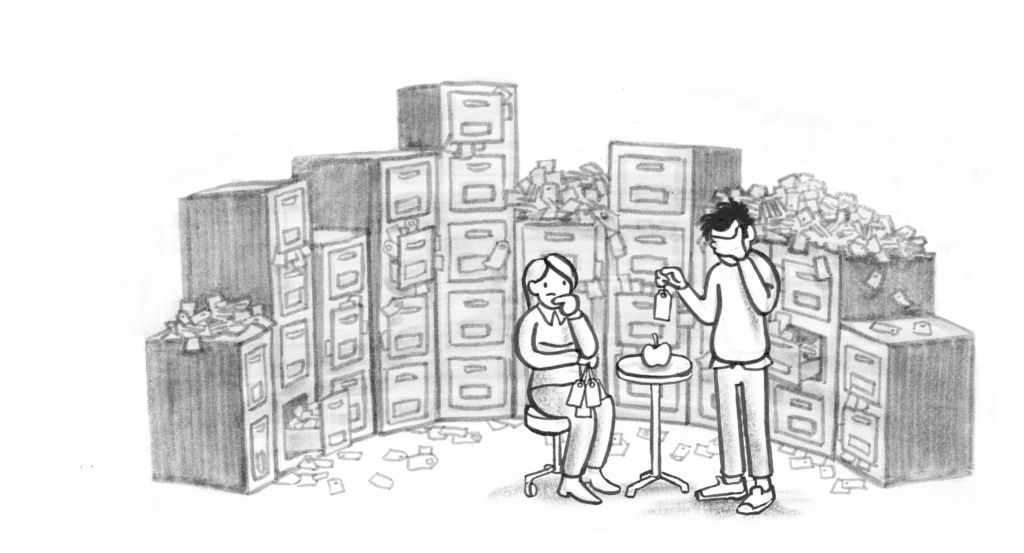 To personer i forgrunn med et stort arkiv fult av tagger /søkordi bakgrunn