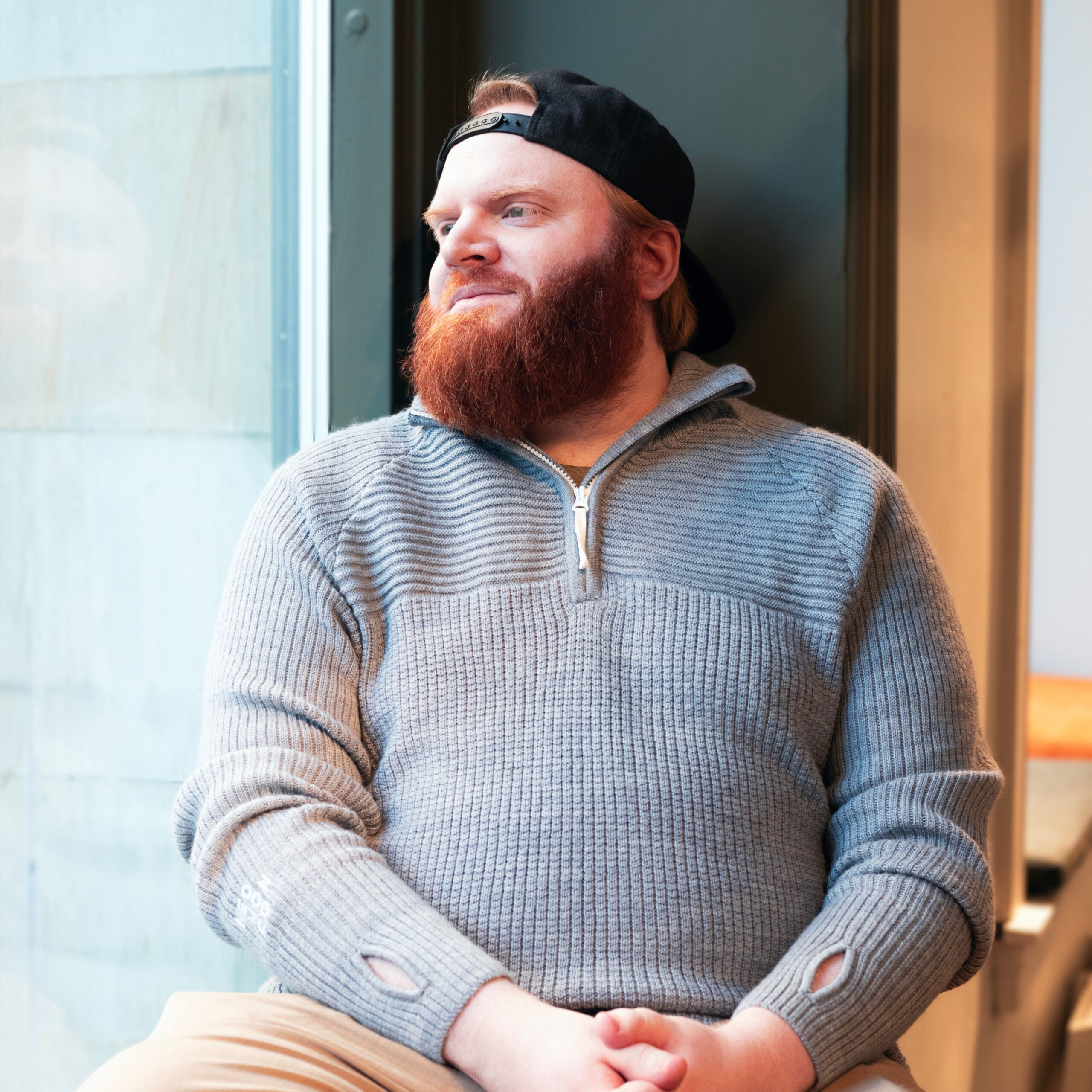 Foto av Marius Jensen i Dekode, Sort genser og sort bakgrunn.